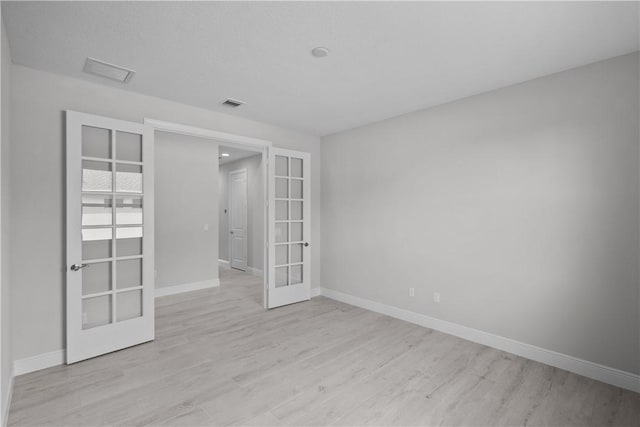 unfurnished room featuring light hardwood / wood-style floors and french doors