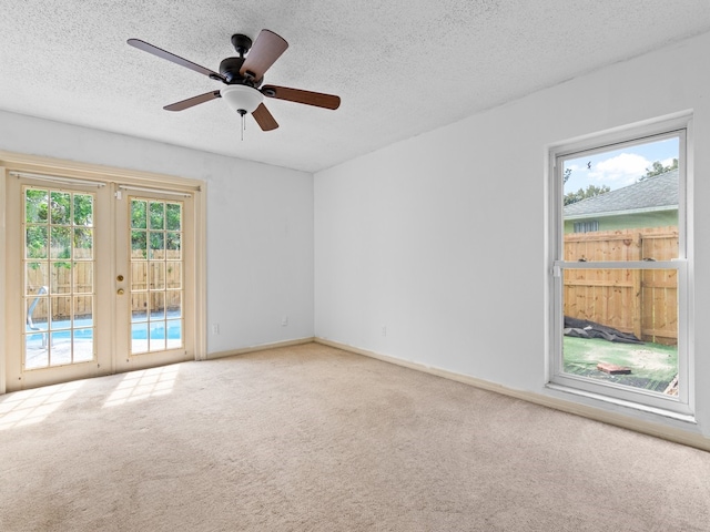 unfurnished room with carpet, french doors, a textured ceiling, and ceiling fan