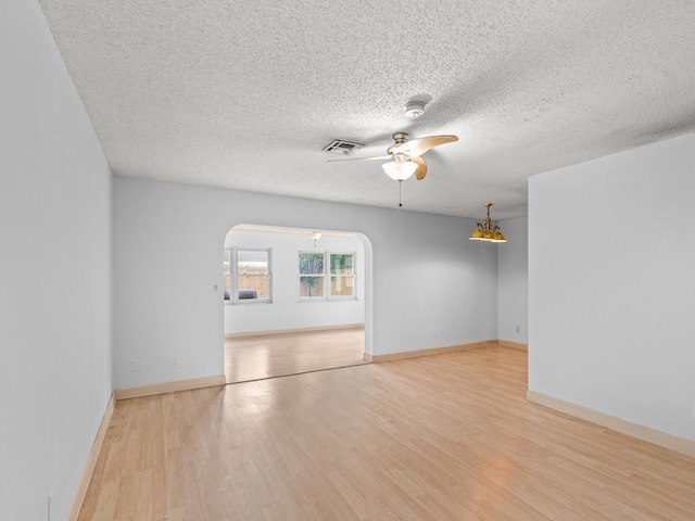 spare room featuring ceiling fan, light hardwood / wood-style floors, and a textured ceiling