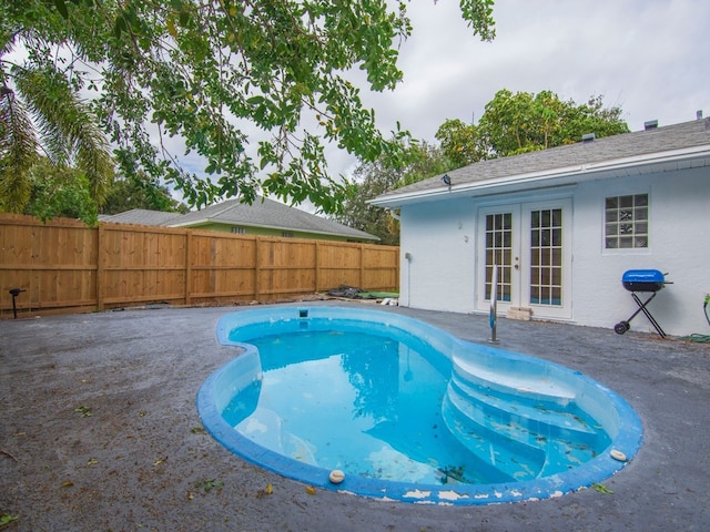 view of swimming pool featuring grilling area and french doors