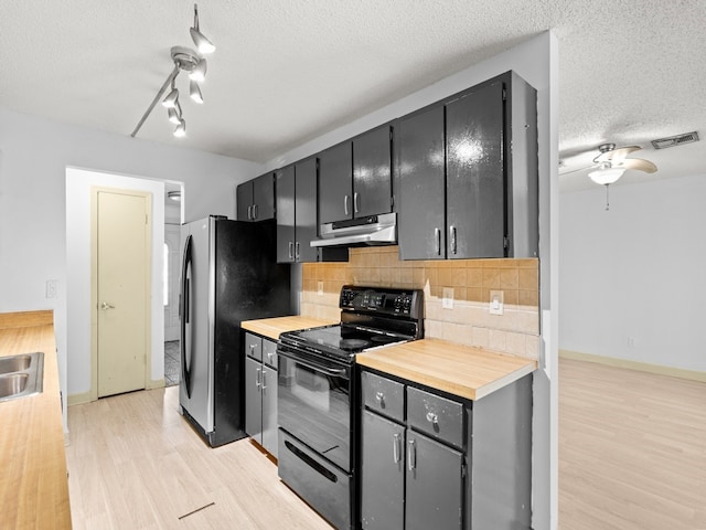 kitchen featuring stainless steel refrigerator, black range with electric cooktop, tasteful backsplash, light hardwood / wood-style flooring, and a textured ceiling