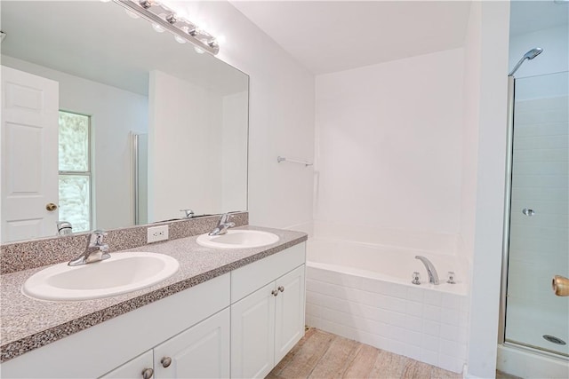 bathroom with wood-type flooring, vanity, and independent shower and bath