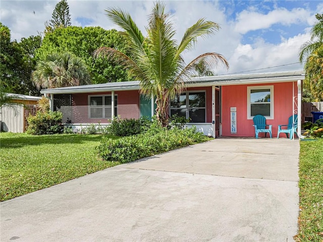 single story home featuring driveway, a front yard, and fence