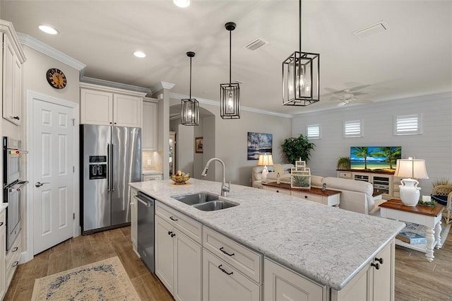 kitchen with wood finished floors, appliances with stainless steel finishes, a sink, and visible vents