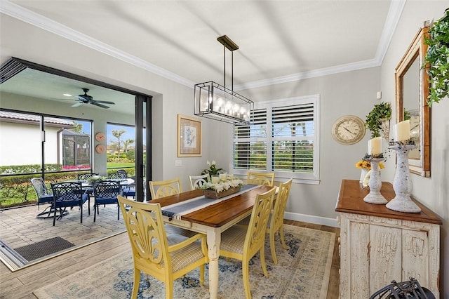 dining area with crown molding, baseboards, wood finished floors, and ceiling fan with notable chandelier