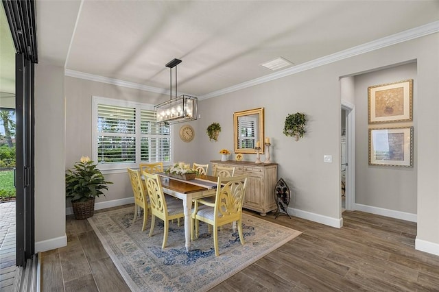 dining room featuring dark wood-style floors, baseboards, and crown molding