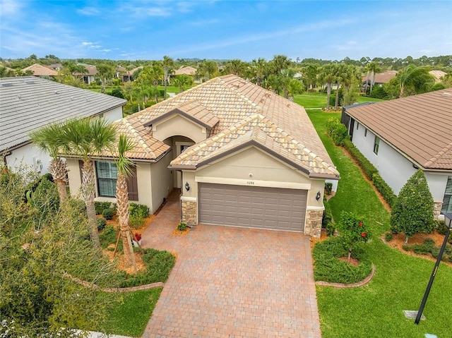 view of front of property featuring a garage, stone siding, decorative driveway, and stucco siding