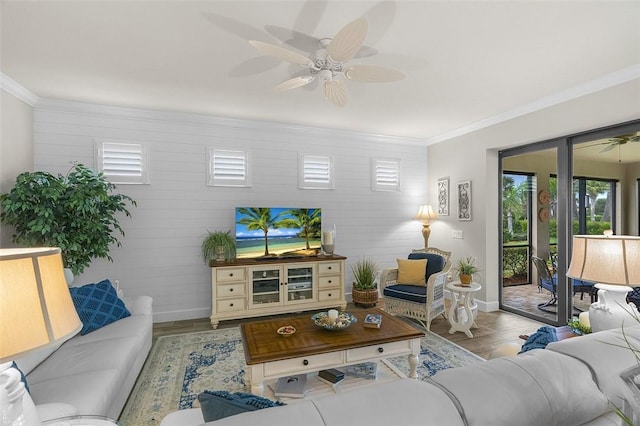 living area featuring ceiling fan, ornamental molding, and baseboards