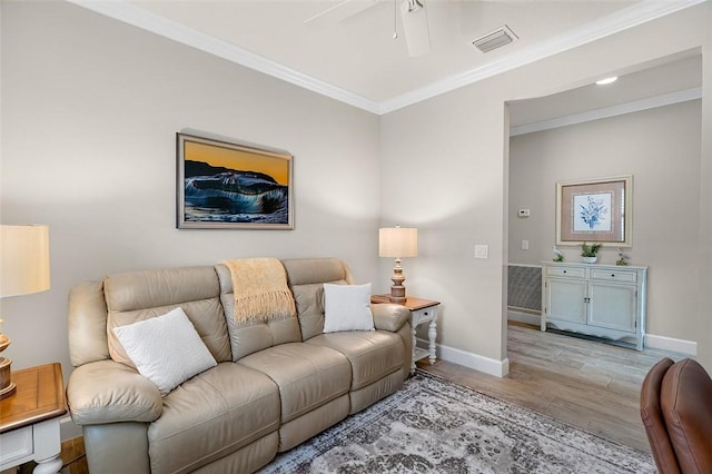 living room with baseboards, visible vents, wood finished floors, and ornamental molding