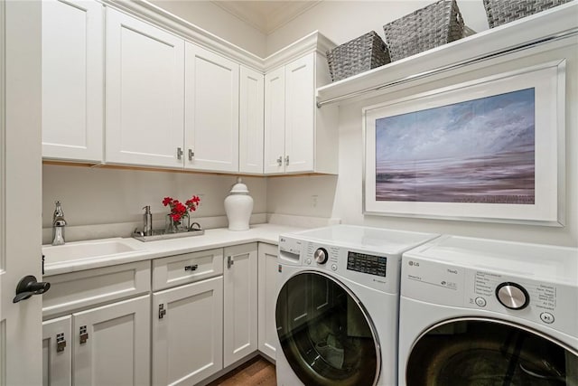 laundry area featuring washer and clothes dryer, hardwood / wood-style floors, cabinets, crown molding, and sink