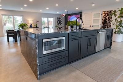 kitchen featuring stainless steel appliances, sink, and a center island with sink