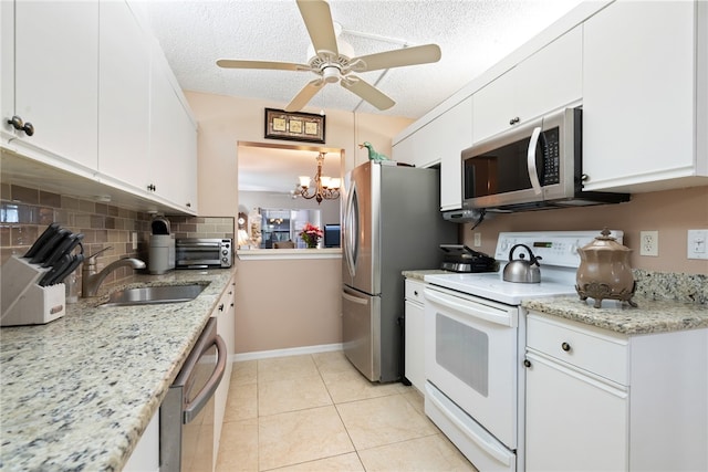 kitchen with white cabinetry, sink, appliances with stainless steel finishes, light tile patterned floors, and backsplash