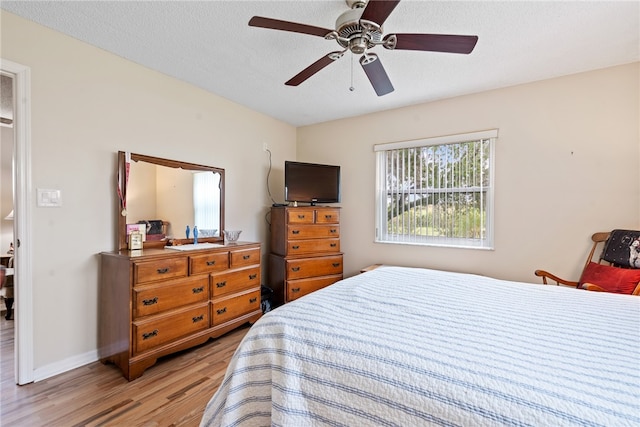 bedroom featuring a textured ceiling, light hardwood / wood-style flooring, and ceiling fan