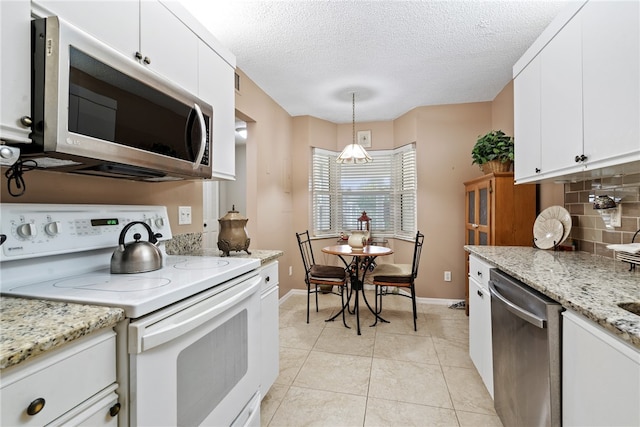 kitchen with tasteful backsplash, white cabinets, decorative light fixtures, and stainless steel appliances