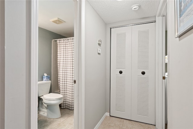 bathroom featuring tile patterned flooring, toilet, and shower / tub combo