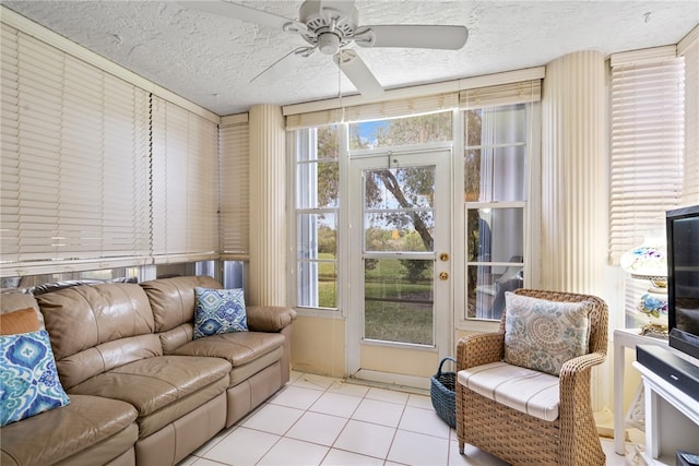 living room featuring a textured ceiling, ceiling fan, and light tile patterned floors