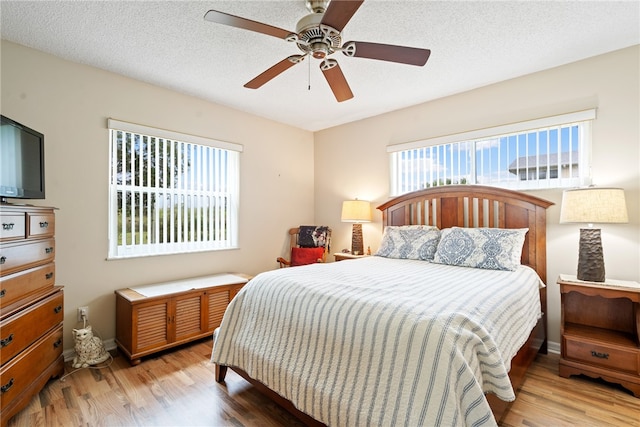 bedroom with hardwood / wood-style flooring, a textured ceiling, and ceiling fan