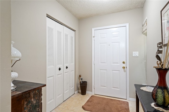 tiled foyer entrance featuring a textured ceiling