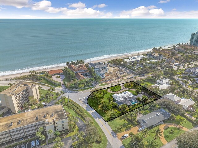 drone / aerial view featuring a water view and a view of the beach