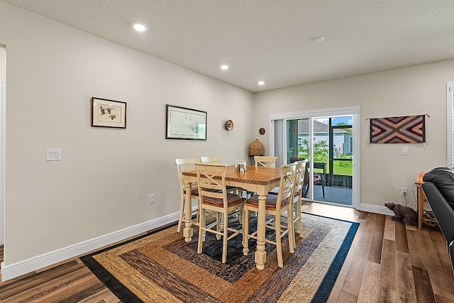 dining space featuring a textured ceiling and dark hardwood / wood-style flooring