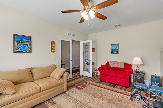 living room featuring a textured ceiling, ceiling fan, dark hardwood / wood-style flooring, and french doors