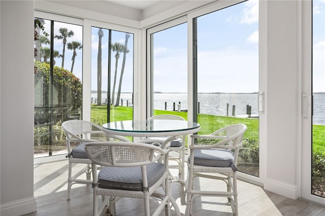 sunroom / solarium featuring a water view