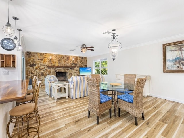 dining area with ornamental molding, ceiling fan with notable chandelier, and light wood-type flooring