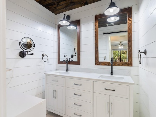 bathroom with ceiling fan, vanity, and wooden walls