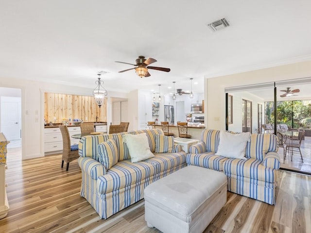 living room with ornamental molding and light wood-type flooring