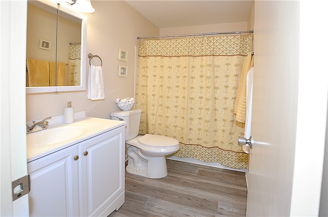 bathroom with a shower with curtain, wood-type flooring, vanity, and toilet