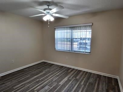 unfurnished room with dark wood-type flooring and ceiling fan