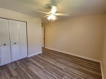 unfurnished bedroom featuring a closet, ceiling fan, and dark hardwood / wood-style floors