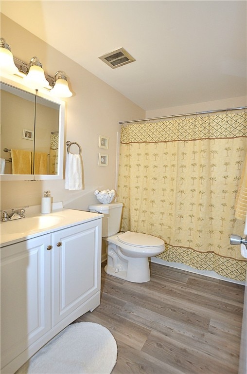 bathroom with hardwood / wood-style floors, vanity, toilet, and a shower with shower curtain