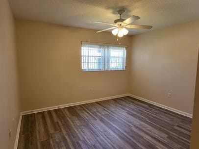 empty room with dark hardwood / wood-style flooring and ceiling fan