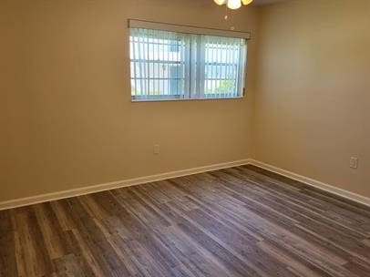 unfurnished room with dark hardwood / wood-style floors and ceiling fan