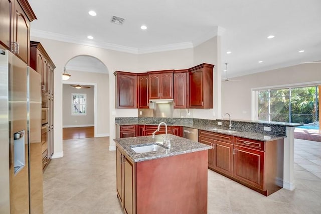 kitchen with a sink, stainless steel appliances, and reddish brown cabinets