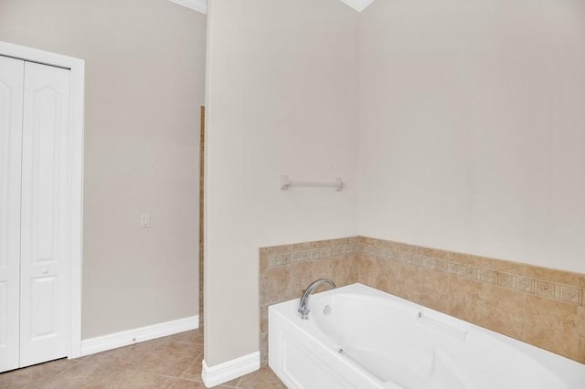 bathroom with baseboards, a bath, and tile patterned flooring