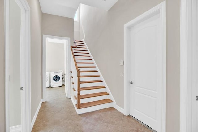 stairs featuring washing machine and clothes dryer, tile patterned floors, and baseboards