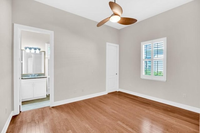 unfurnished room featuring a ceiling fan, wood finished floors, and baseboards