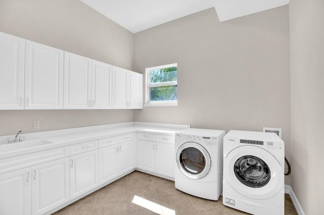 laundry area featuring independent washer and dryer, a sink, cabinet space, light tile patterned flooring, and baseboards