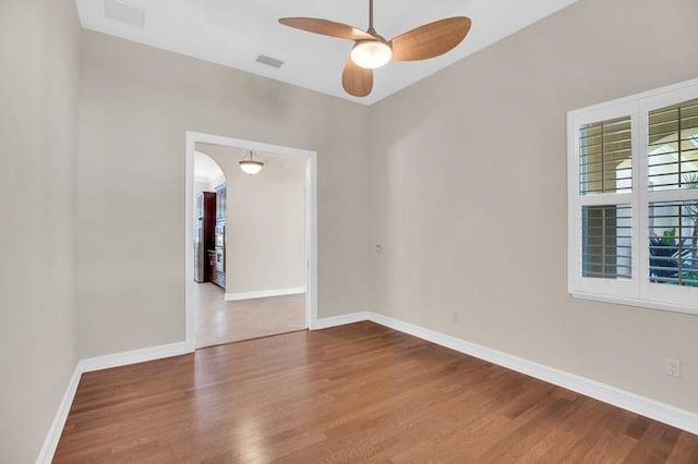 unfurnished room featuring ceiling fan, baseboards, and wood finished floors