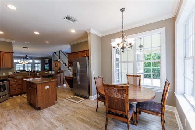 dining area with ornamental molding, ceiling fan with notable chandelier, light hardwood / wood-style floors, and sink