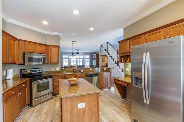 kitchen featuring stainless steel appliances, sink, kitchen peninsula, hanging light fixtures, and a kitchen island