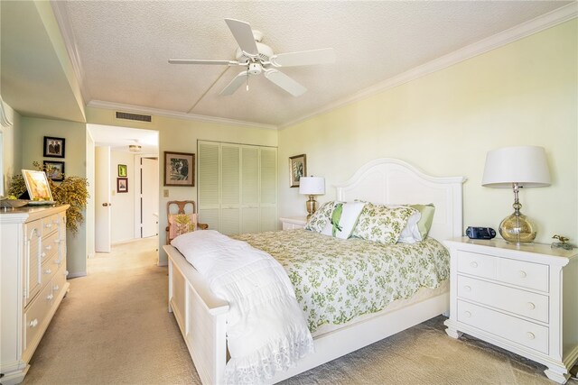 carpeted bedroom featuring a textured ceiling, ceiling fan, crown molding, and a closet