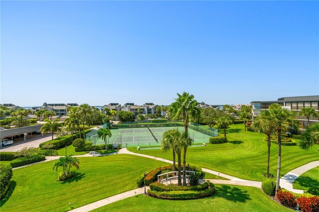 surrounding community featuring tennis court and a lawn