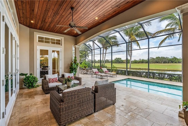 view of swimming pool featuring an outdoor living space, a patio area, french doors, and a water view