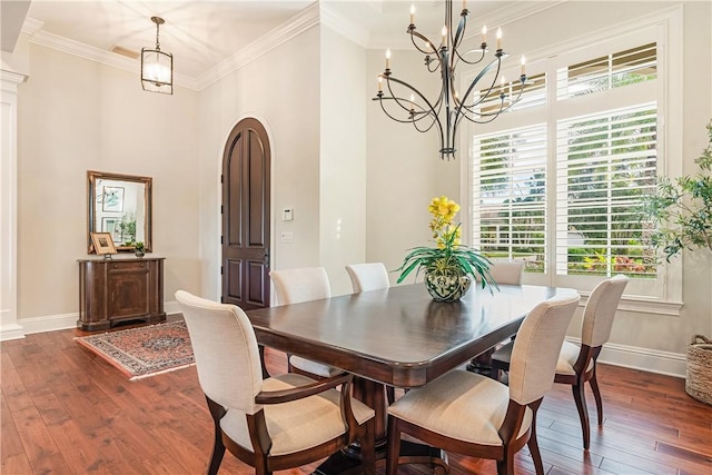 dining area featuring crown molding, dark hardwood / wood-style floors, and a chandelier