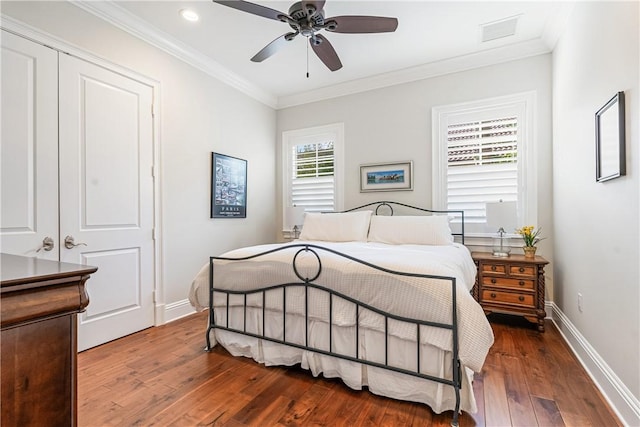 bedroom with dark wood-type flooring, ceiling fan, and ornamental molding