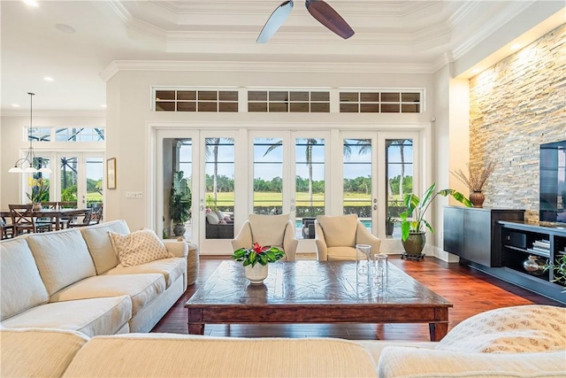 living room featuring hardwood / wood-style floors, crown molding, a healthy amount of sunlight, and ceiling fan