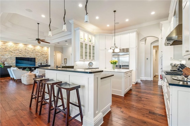 kitchen featuring white cabinetry, crown molding, built in fridge, and ceiling fan